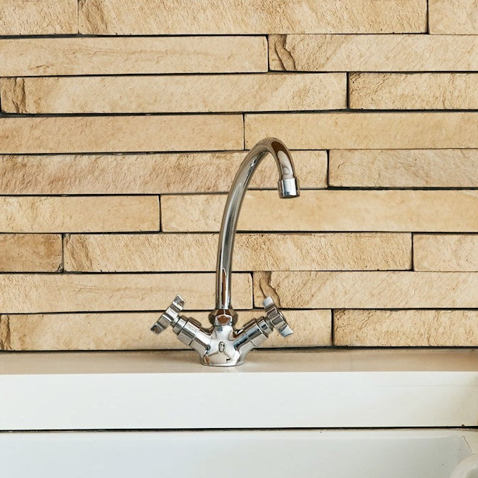 kitchen sink with stone backsplash