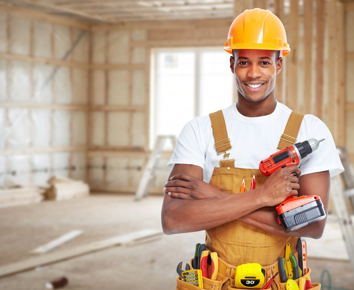 Man wearing a hard hat and holding a drill