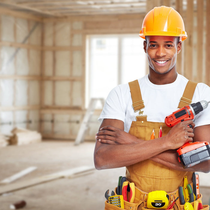 Man wearing a hard hat and holding a drill