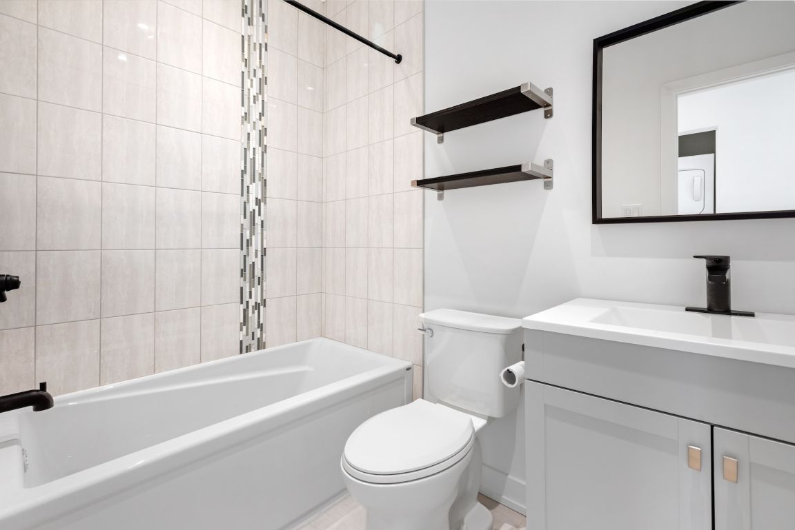 A small white bathroom with black accents